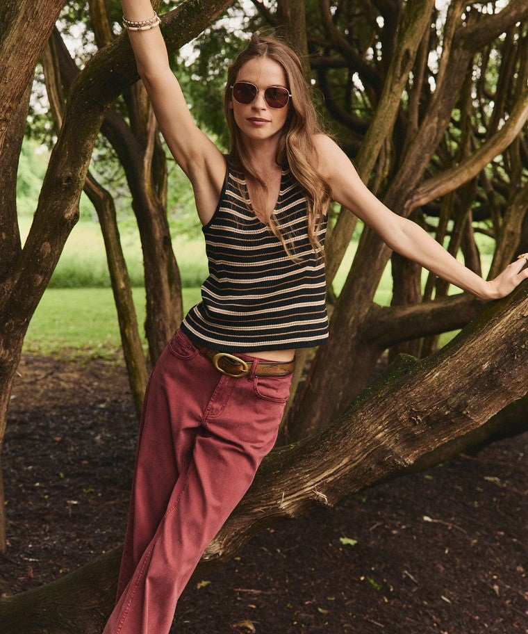 Model in a striped tank and wide-leg pant, a breathable base built for unpredictable early-fall weather