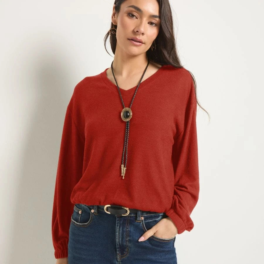 Blonde wearing an off-shoulder casual burgundy sweatshirt.