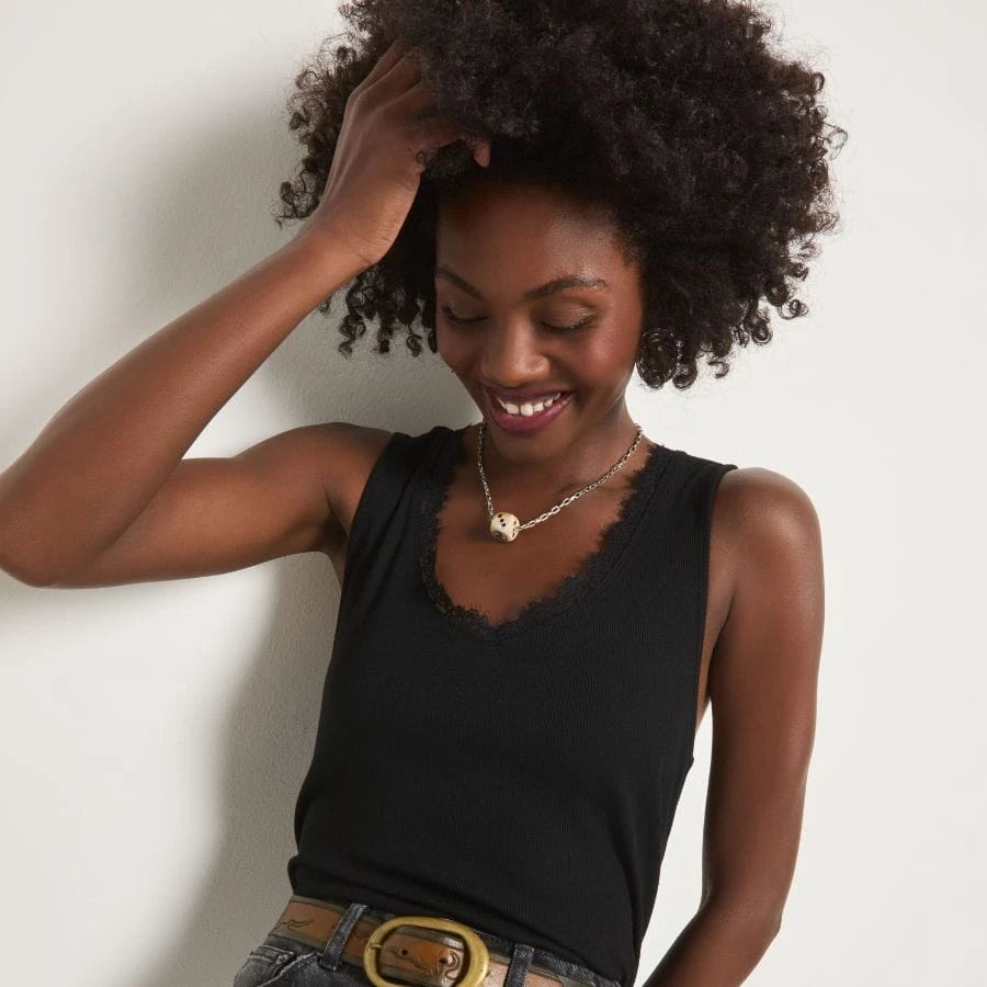 Smiling brunette wearing a red v-neck tank top.