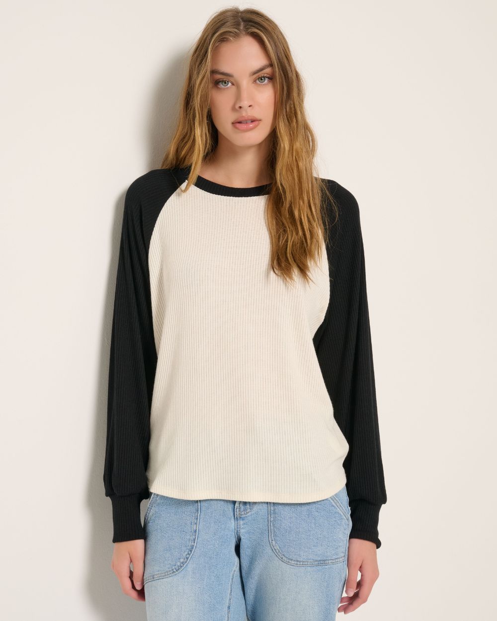 Blonde wearing an off-shoulder casual burgundy sweatshirt.