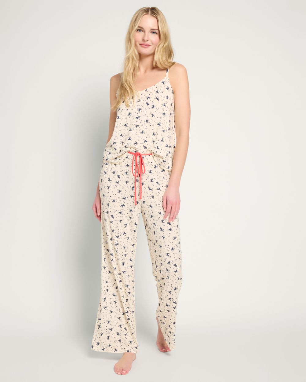 Blonde wearing a lilac pajama set with a spaghetti strap tank top and shorts.